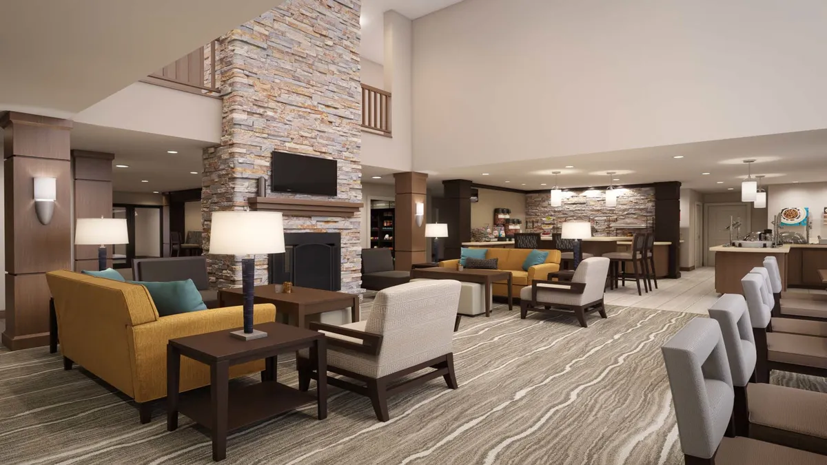 This image showcases an inviting interior with a stone fireplace, comfortable seating, and modern lighting fixtures. The layout feels cozy and designed for relaxation, with ample space for lounging or enjoying quiet moments.